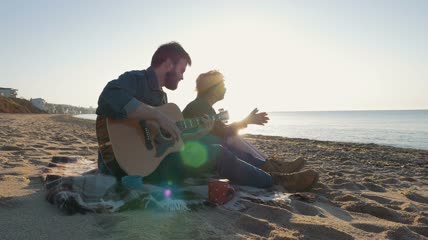 情侣在海滩弹着吉他实拍视频
