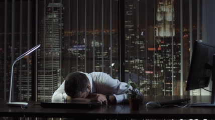 疲惫的商人躺在办公室的桌子上睡觉实拍视频