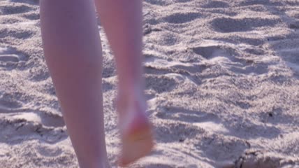 跟拍美女在沙滩上走路扬起沙子