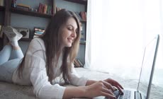 快乐的年轻漂亮的女人使用笔记本电脑