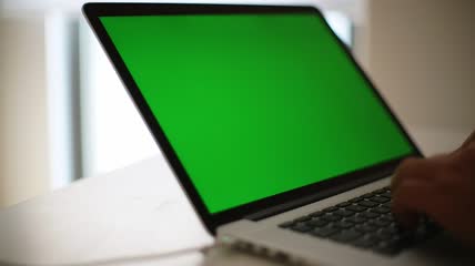 一名男子在一台绿色屏幕的笔记本电脑上工作视频