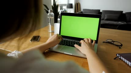 一位女士在桌上的笔记本电脑上打字视频