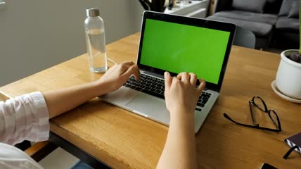 实拍在家中用笔记本电脑工作的女性