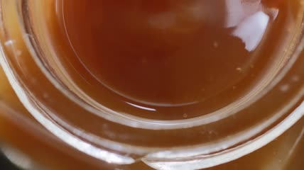 黄色蜂蜜密度缓慢下落倒进瓶子浓稠蜂蜜流动高清视频实拍