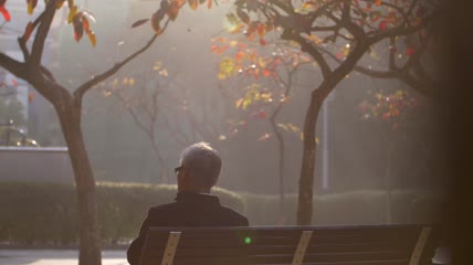 冬天孤独的老人在公园独坐看孩子们嬉戏