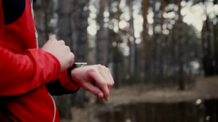 慢跑者在森林中检查智能手表的心率实拍