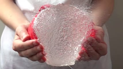 一个捏爆水球的女孩特写实拍