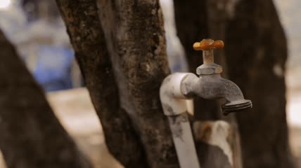 一名男子关上滴水的水龙头特写