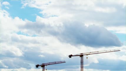 多云天空下的建筑吊车塔