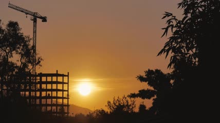 日落在一座在建的建筑物后面实拍