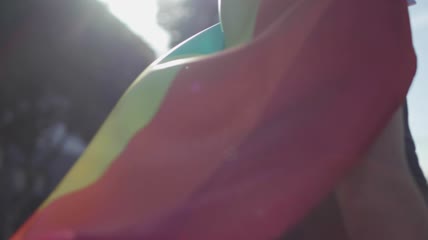 身穿彩虹旗当斗篷的男子特写实拍
