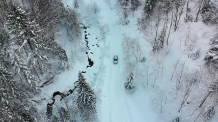 一辆汽车在积雪的道路上行驶航拍