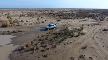 一辆汽车荒野土路行驶空中跟踪航拍