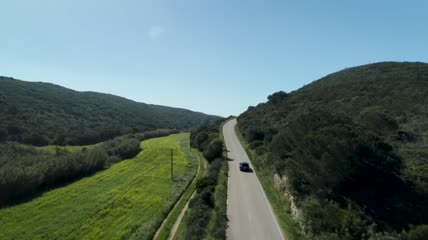 在山区的公路上行驶的汽车航拍