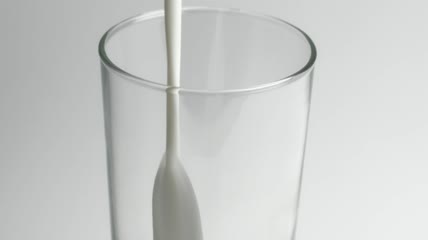 把牛奶倒进玻璃杯里特写实拍