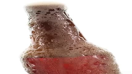 白色背景上的啤酒瓶溢出泡沫特写实拍