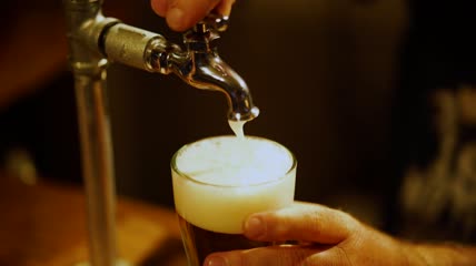 酒吧里的调酒师正在倒啤酒特写实拍