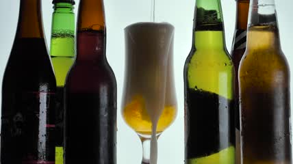 泡沫啤酒从玻璃杯里溢出来特写实拍