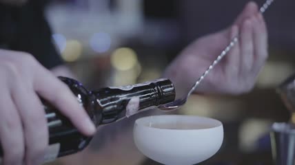 调酒师把樱桃酒量进勺子里特写实拍