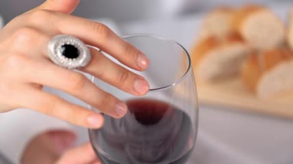 一名妇女沿着玻璃杯的边缘滑动手指特写实拍