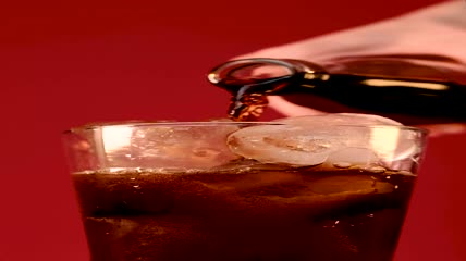 用瓶子里的汽水装满玻璃杯特写实拍