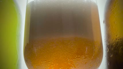在玻璃杯中倒入起泡啤酒特写实拍