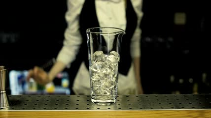 在鸡尾酒杯里加冰特写实拍