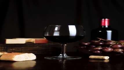 桌子上有葡萄酒、奶酪、葡萄和面包实拍