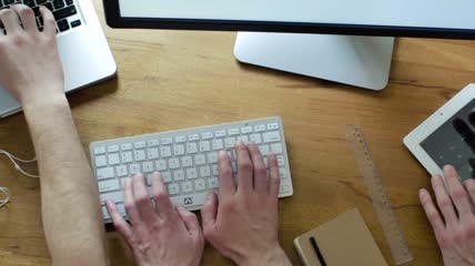 双手在桌子上的不同键盘上工作特写视频
