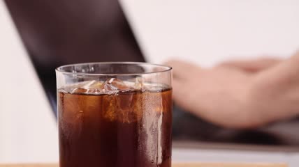 在咖啡旁用笔记本电脑打字的人特写实拍