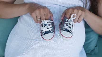 孕妇拿着小婴儿鞋特写实拍