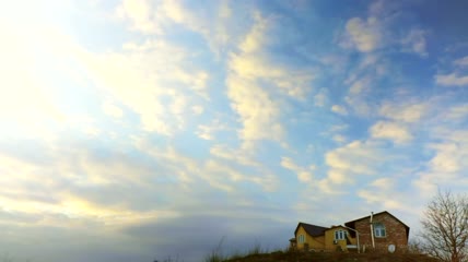 从乡间小屋上空掠过的云彩实拍