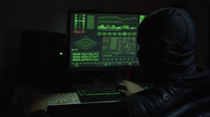 带着巴拉克拉瓦在电脑前工作的黑客特写
