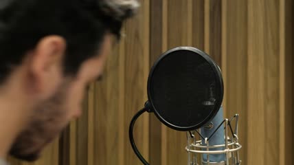 一名男子在录音棚里唱歌