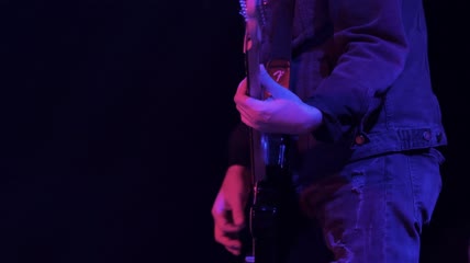 在舞台上演奏歌曲的吉他手特写实拍