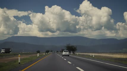 在群山环绕的高速公路上行驶实拍