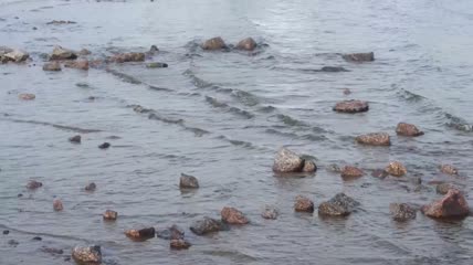 鹅卵石上的轻柔波浪实拍