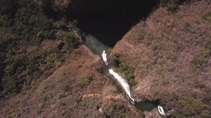 红色岩石和树木之间的瀑布航拍