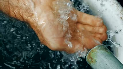 一股水柱落在一只手中特写实拍