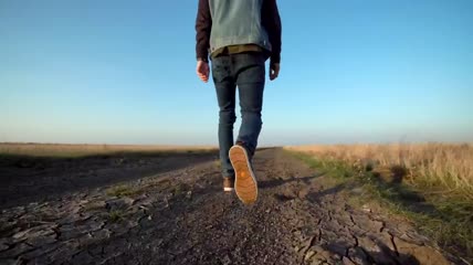 一个走在土路上的人特写实拍