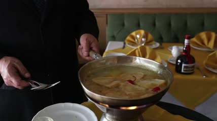 身穿黑色西装的厨师用火做饭特写