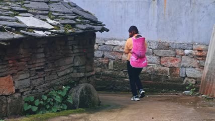 4k实拍农村妇女辈娃外出经过石板房