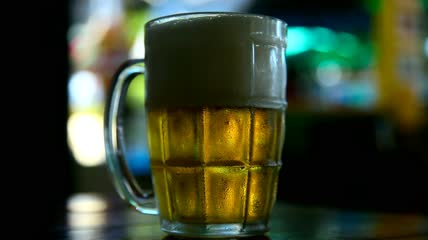 杯子里装着冰啤酒特写实拍