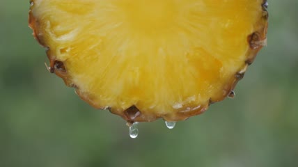 菠萝片流出一滴果汁的特写镜头