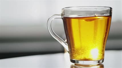 勺子搅拌透明玻璃茶杯里的糖特写
