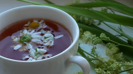 水倒入放着白色菊花的杯子里特写