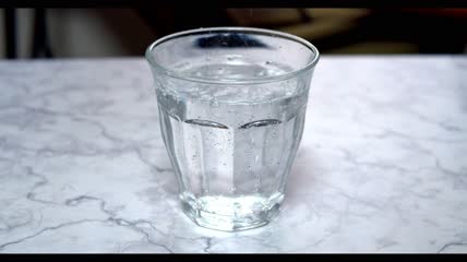 水倒入桌子上的玻璃杯里特写
