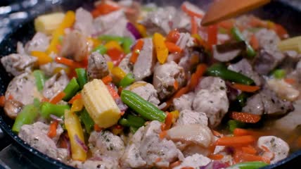 热气腾腾的菜肴在平底锅上炒制特写