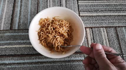 碗里的叉子搅拌着炒面特写