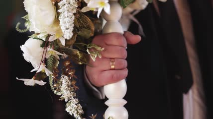 戴戒指的已婚男人手拿一束鲜花特写